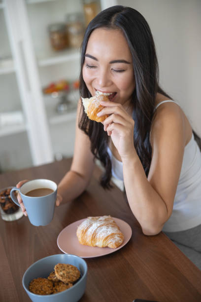 istock Young lovely lady eating a crescent roll 1188962249