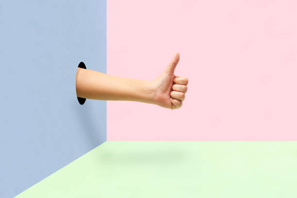 istock Hand making thumbs up like a approval sign  on colorful background. 1188963981