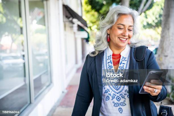 Mexican Businesswoman Texting Stock Photo - Download Image Now - Senior Adult, Using Phone, Mobile Phone