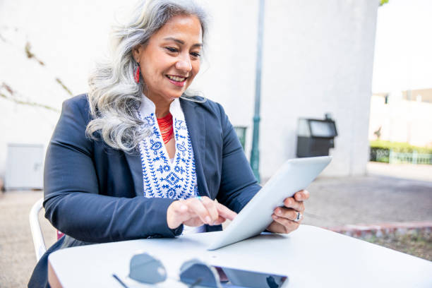 istock Latina Businesswoman Using Tablet at Cafe 1188966343