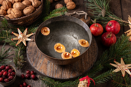 Candles made from nut shells floating in a bowl of water - old Christmas custom