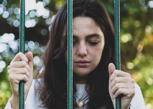 istock sad woman behind barriers 1188977932