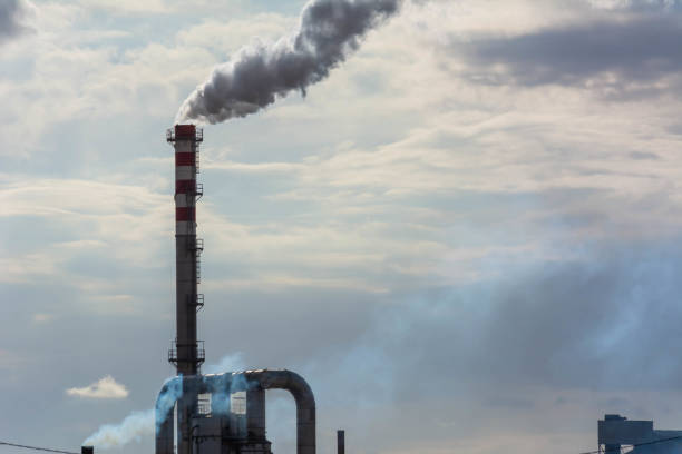 istock Red and White Chimney Smoking on Cloudy Sky Background. Pollution in the Atmosphere 1188978562