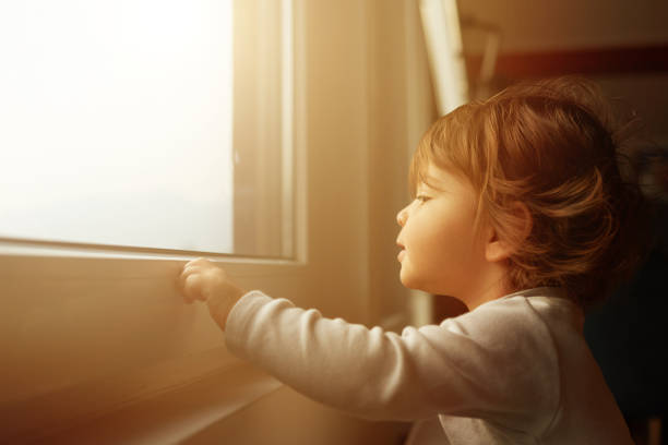 istock Baby girl at the window 1188978710
