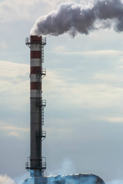 istock Red and White Chimney Smoking on Cloudy Sky Background. Pollution in the Atmosphere 1188978713