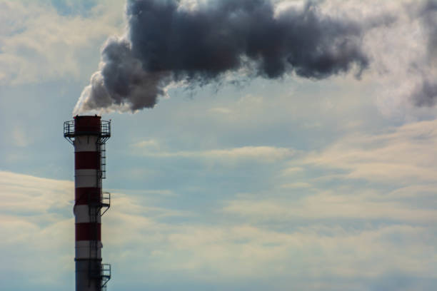 istock Red and White Chimney Smoking on Cloudy Sky Background. Pollution in the Atmosphere 1188978823