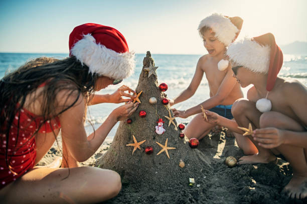 istock Kids decorating sand Christmas tree on summer Christmas 1188982930