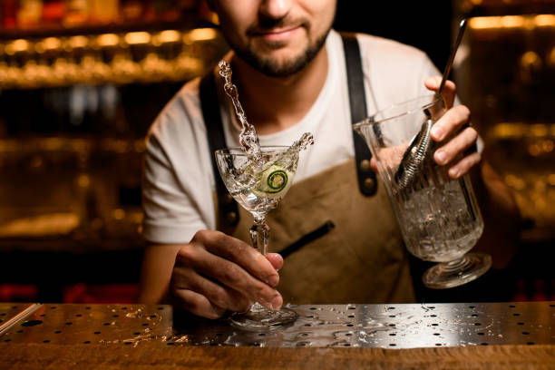 istock Bartender mixing with splash an alcoholic cocktail with a cucumber slice 1188988877