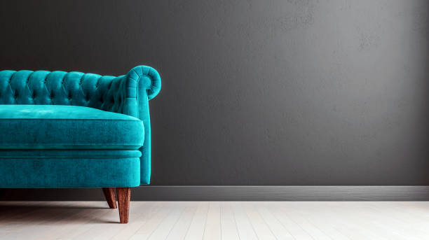 Living room dark grey interior wall mock up with turquoise blue colored velvet sofa, empty grey wall with free space on the right, 3D render, 3D illustration stock photo