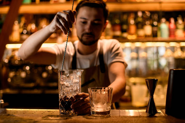 istock Bartender stirring a brown alcoholic drink with a spoon in the mixing glass 1188989689