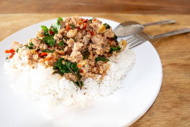 istock Rice topped with stir-fried pork and basil in a white dish. (Front focus) 1188991597