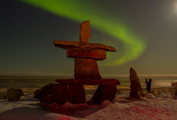 istock Northern lights and inukshuk with tourist 1188992575