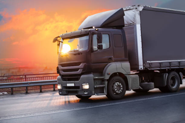 istock truck goes on highway on sunset 1188993672