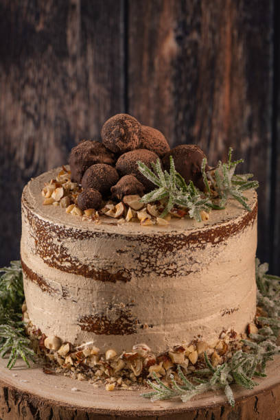 istock Delicious naked chocolate and hazelnuts cake on table rustic wood kitchen countertop. 1188994805
