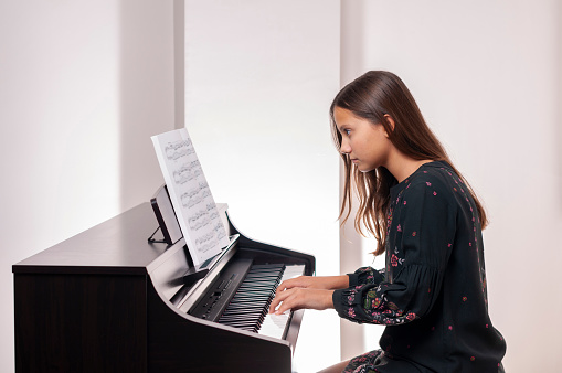 Girl playing the piano, she is very careful,