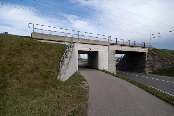 white concrete railway bridge with car and pedestrian underpass maximum high 2.90 meters wide angle view