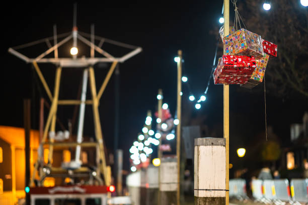 Sainta Claus presenta corde di illuminazione a bulbo lungo la banchina di un porto - foto stock