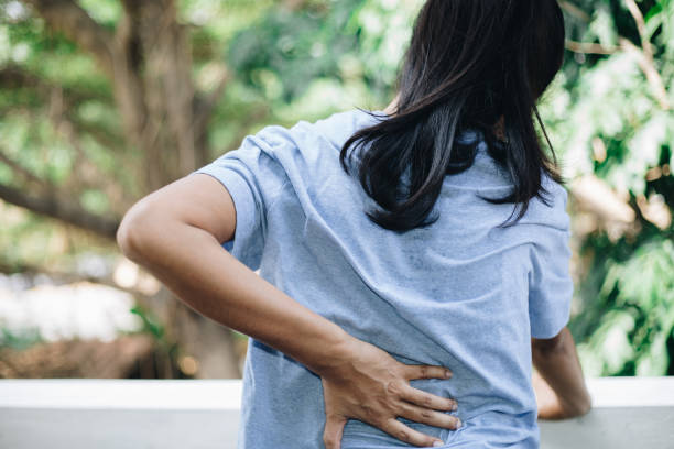 istock Backache. Young woman suffering from back pain 1189002501