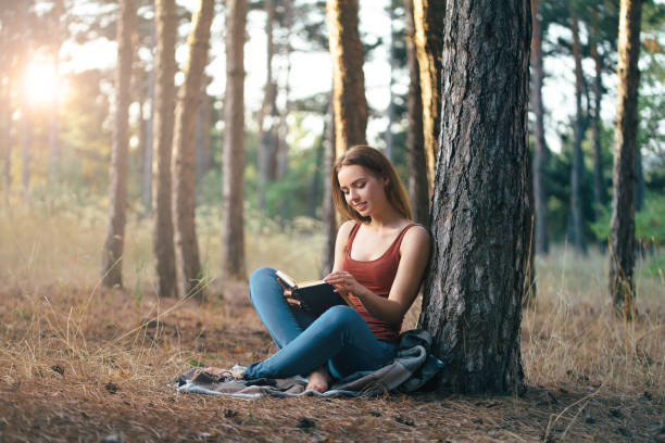 istock woman read in nature under tree 1189008257