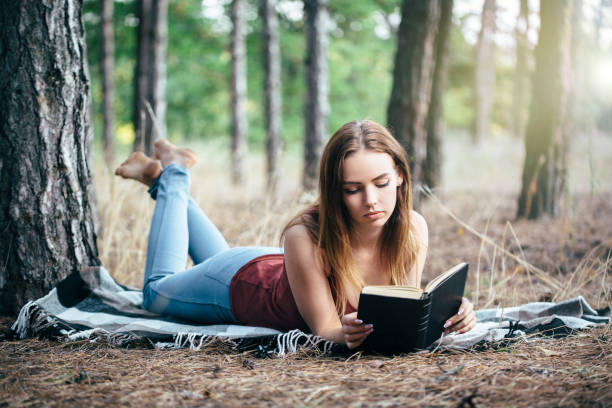 istock woman read in nature under tree 1189008282