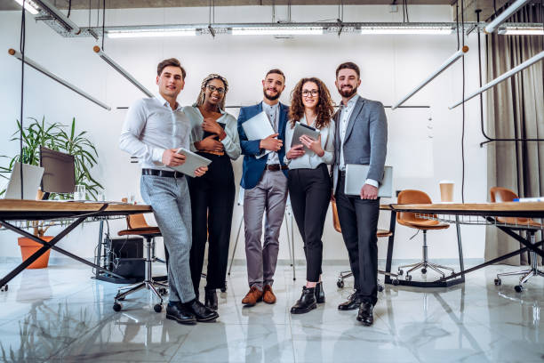 istock Ready to work! Young business team holds laptops and tablets in their hands in preparation for the beginning of a busy day. Business concept - partnership, unity, friendship. 1189010370