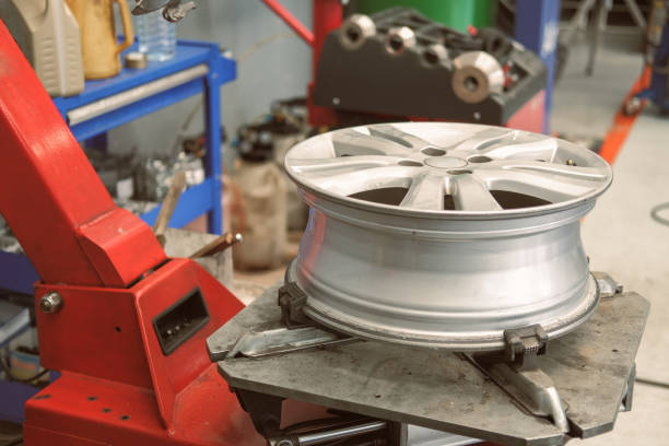 istock technician removing rubber from car wheel disc & balancing tyre on balancer in auto repair garage 1189010698