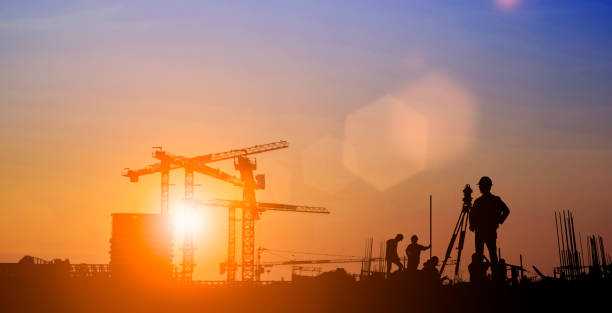 istock Silhouette of Survey Engineer and construction team working at site over blurred  industry background with Light fair.Create from multiple reference images together 1189010879