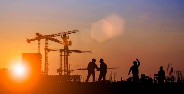 istock Silhouette of Survey Engineer and construction team working at site over blurred  industry background with Light fair Film Grain effect.Create from multiple reference images together 1189010882