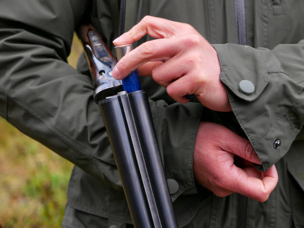 junger mann steht und lädt seine schrotflinte mit patronen während eines fasanenschießens - pheasant hunting fotos stock-fotos und bilder