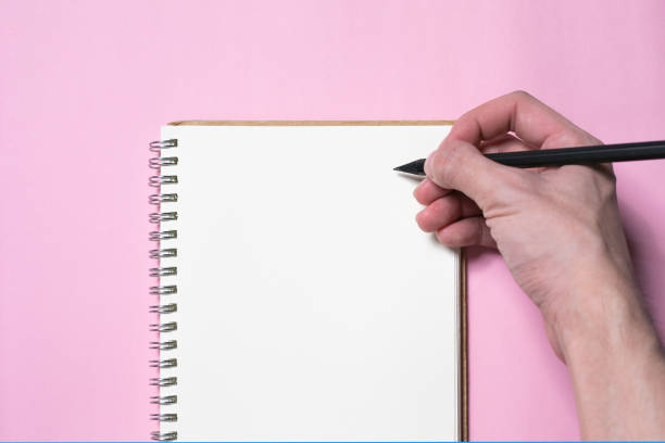 istock top view of hand writing or drawing in blank notebook page mock up background, education and lifestyle concept 1189011478