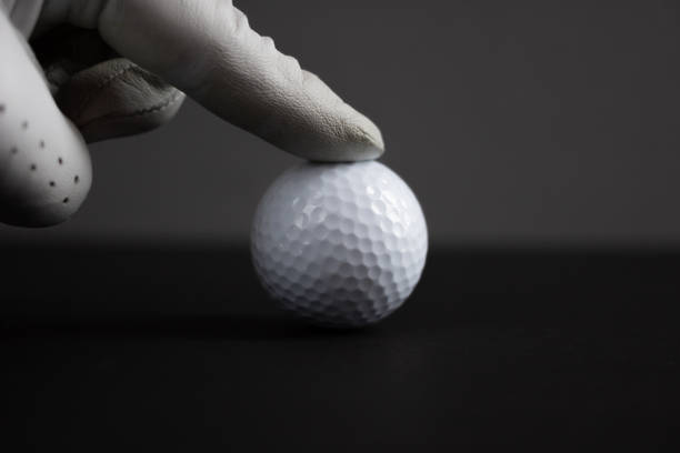 istock finger in glove touch golf ball black background 1189015266