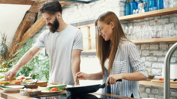istock Young couple making dinner together at home 1189015707