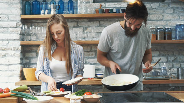 istock Young couple making dinner together at home 1189015723