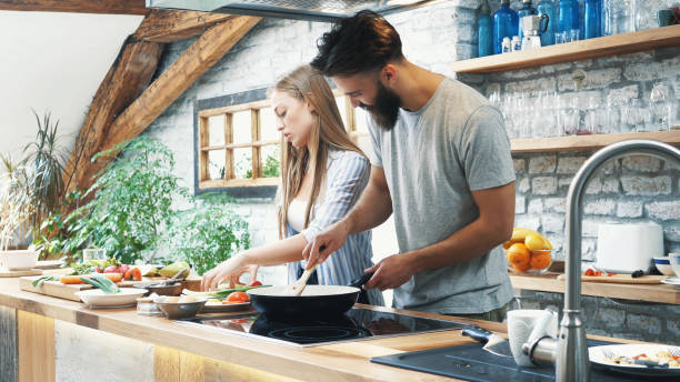 istock Young couple making dinner together at home 1189015727