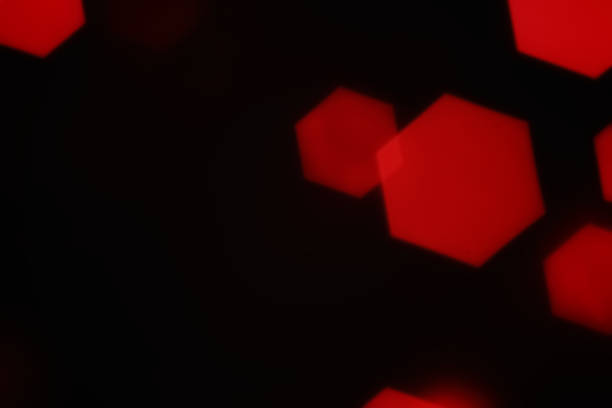 istock Red hexagonal bokeh lights on dark background from unfocused macro 1189019518