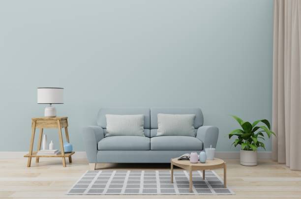 istock Empty living room with blue sofa, plants and table on empty blue wall background. 1189026144