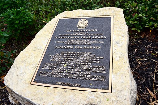 Twenty-five-year award plaque displayed at the Japanese Tea Garden. Picturesque landscaped garden located in Brackenridge Park was built in between 1918-1942 and continue renovations throughout the years.  The garden was also known as the Chinese Tea Garden during World War II.