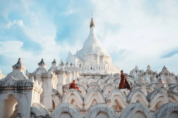 Photo of Novices under umbrellas at historic temple