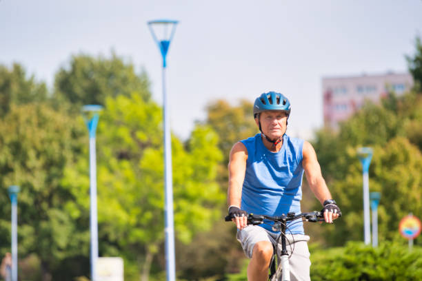 istock Senior male athlete riding bicycle in park 1189047848
