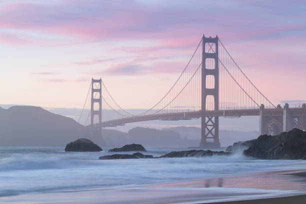 istock Classic panoramic view of famous Golden Gate Bridge seen from scenic Baker Beach in beautiful golden evening light on a sunset with blue sky and clouds in summer, San Francisco, California, USA 1189050077