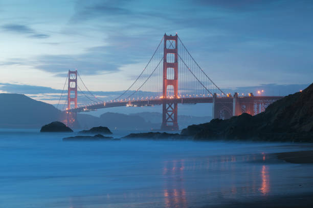 istock Classic panoramic view of famous Golden Gate Bridge seen from scenic Baker Beach in beautiful golden evening light on a sunset with blue sky and clouds in summer, San Francisco, California, USA 1189050132