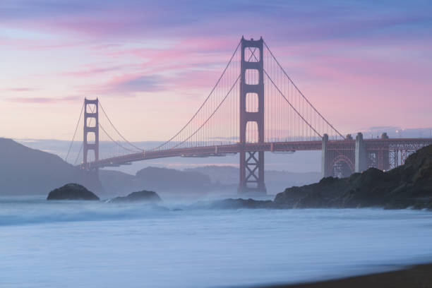 istock Classic panoramic view of famous Golden Gate Bridge seen from scenic Baker Beach in beautiful golden evening light on a sunset with blue sky and clouds in summer, San Francisco, California, USA 1189050133