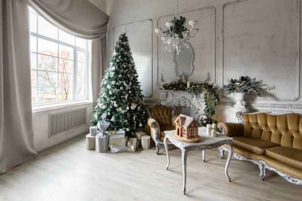istock Christmas morning. Classic luxury apartments with a white fireplace, christmas tree, sofa, large windows and chandelier. 1189056095