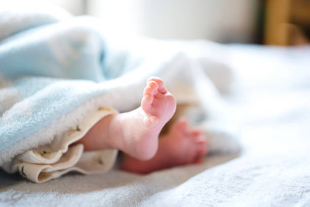 istock Newborn baby on a white and light blue blanket - tiny baby feet. 1189060455