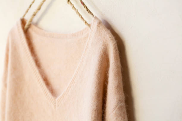 jasnoróżowy sweter wiszący na wieszaku na ubrania na białym tle. - angora wool zdjęcia i obrazy z banku zdjęć