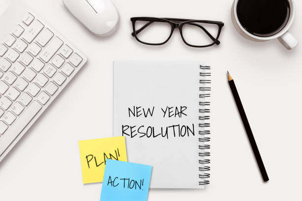 istock New Year Resolution Goal List 2020 - Business office desk with notebook written in handwriting about plan listing of new year goals and resolutions setting. 1189063236