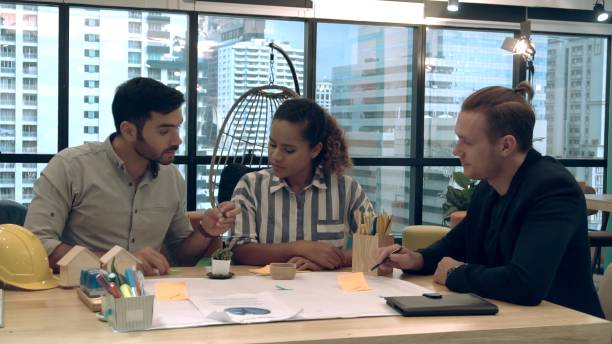 istock Creative business people group having conversation at office desk in workplace. 1189063974