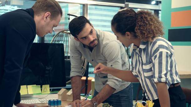 istock Creative business people group having conversation at office desk in workplace. 1189063997