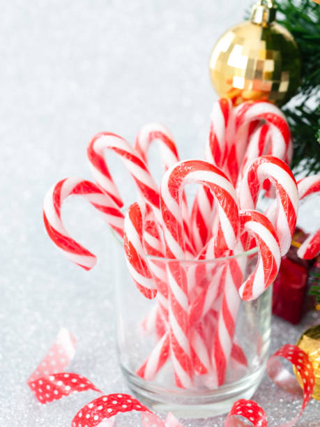 istock Christmas candy sticks on glass with silver bokeh background. 1189066676