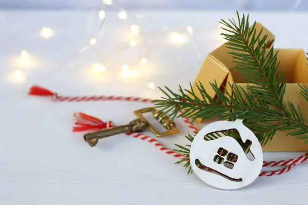 ball-shaped decoration with a house under the tree next to an open gift and a golden retro key